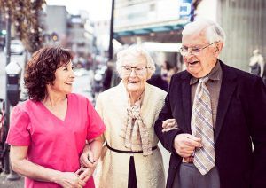 elderly couple with dementia enjoying a night out with the help from a nurse next door home care services care giver