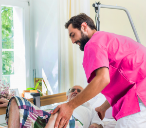 Professional care giving nurse helping an elderly man into his own bed in his own home