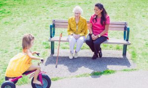 Nurse next door care giver providing respite care to an elderly lady with alzheimer's helping her to enjoy a community outing