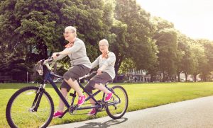 two elderly ladies riding a bike being active, healthy and happy with Nurse Next Door Home Care Agency