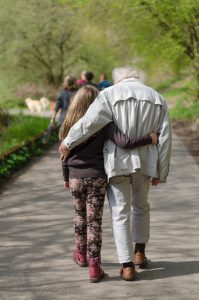 elderly man and grandchild walking arm in arm