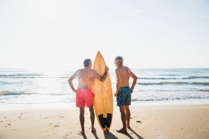 older men surfing at the beach