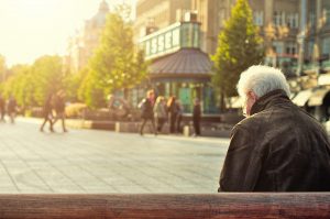 elderly old senior man sitting alone on a bench