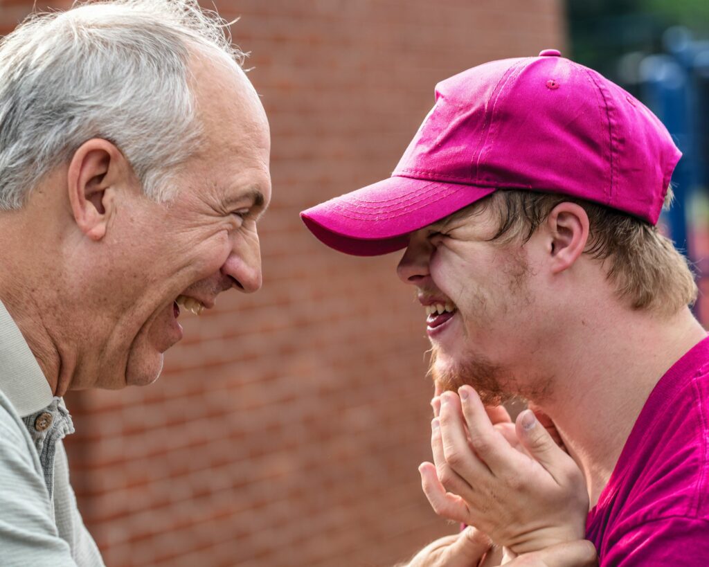 Man with his son who has a disability smiling together